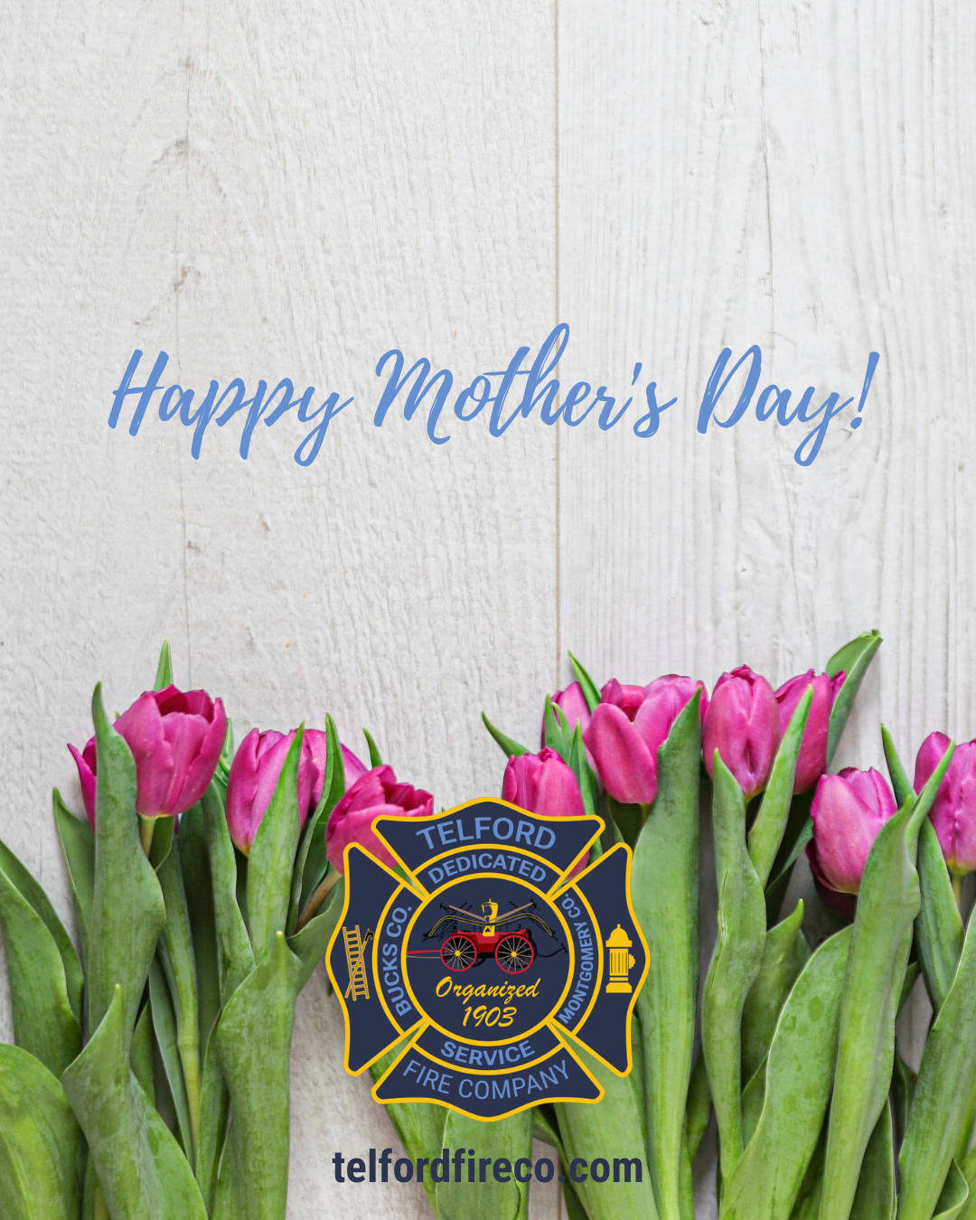 A row of pink tulips against a light wooden background with the text "Happy Mother's Day!" in blue above, and the Telford Fire Company badge and website at the bottom.